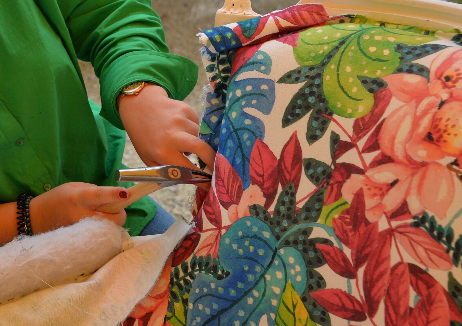 Une femme travaille un tissu coloré, il y a un texte Bienvenue sur NuMAD sur le devant de cette image